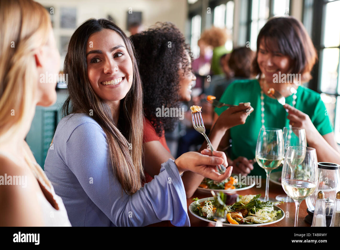 Group Of Female Friends Enjoying Meal In Restaurant Together Stock Photo