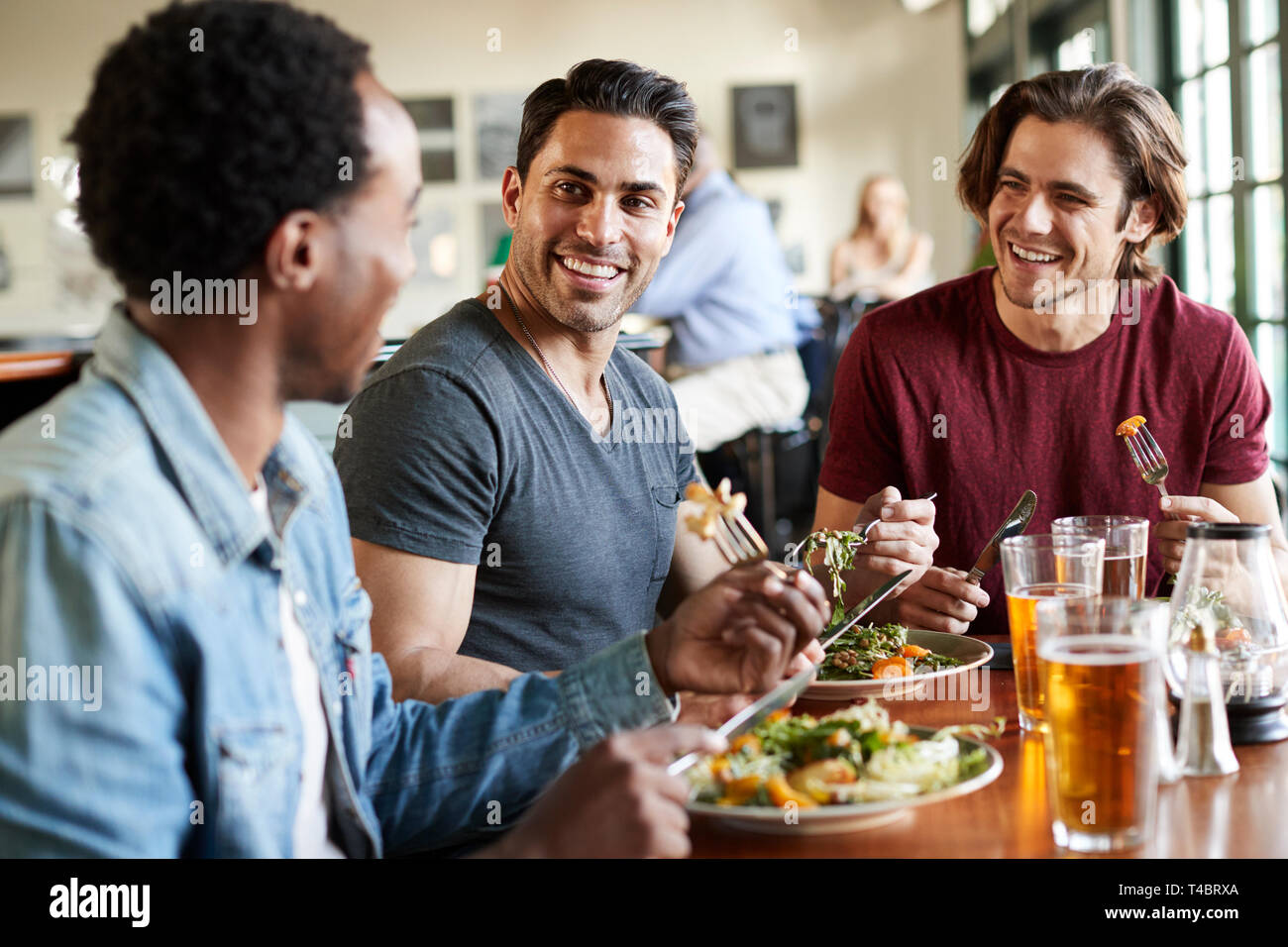 Group Of Male Friends Enjoying Meal In Restaurant Together Stock Photo