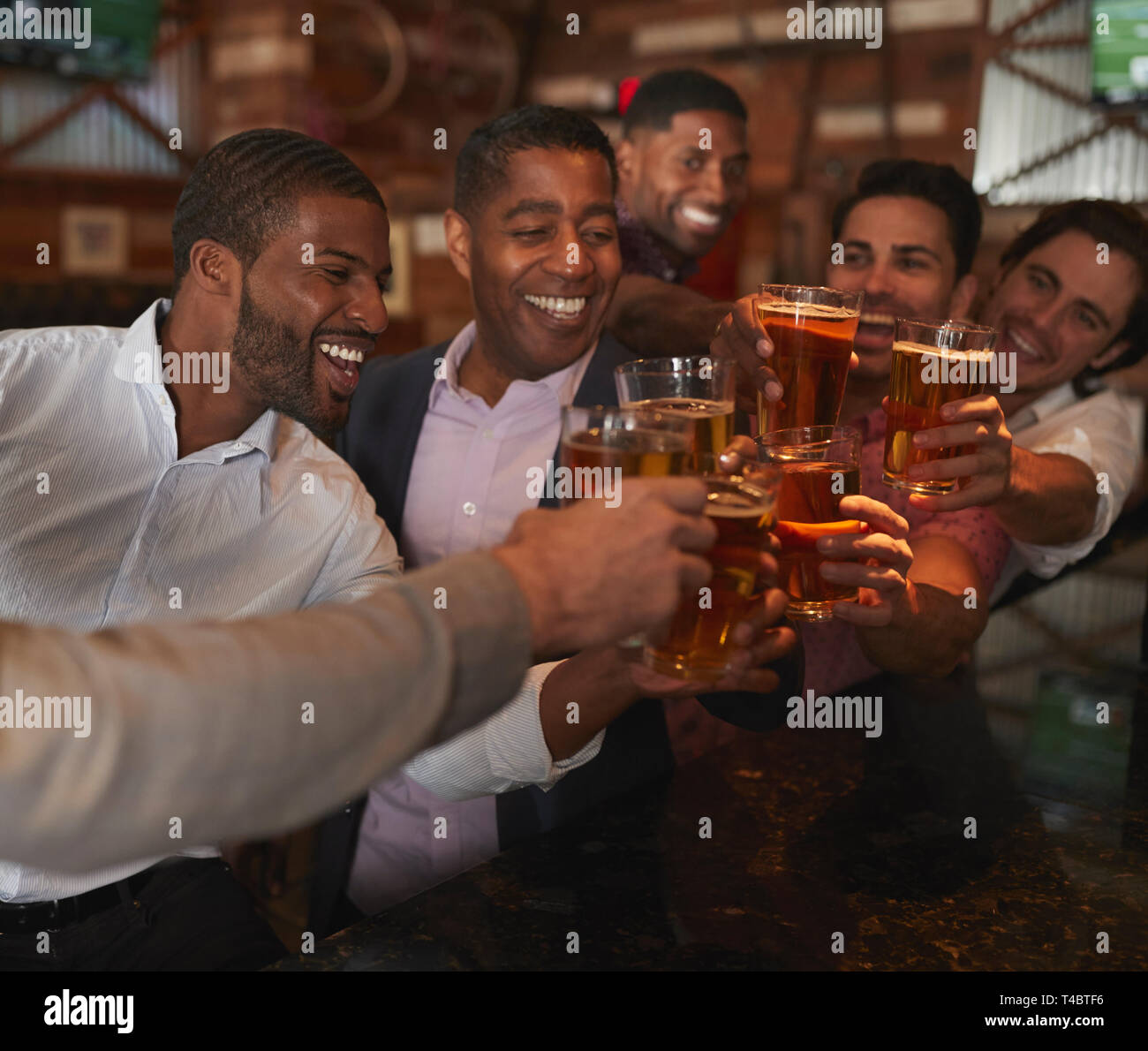 Group Of Male Friends On Night Out For Bachelor Party In Bar Making Toast Together Stock Photo