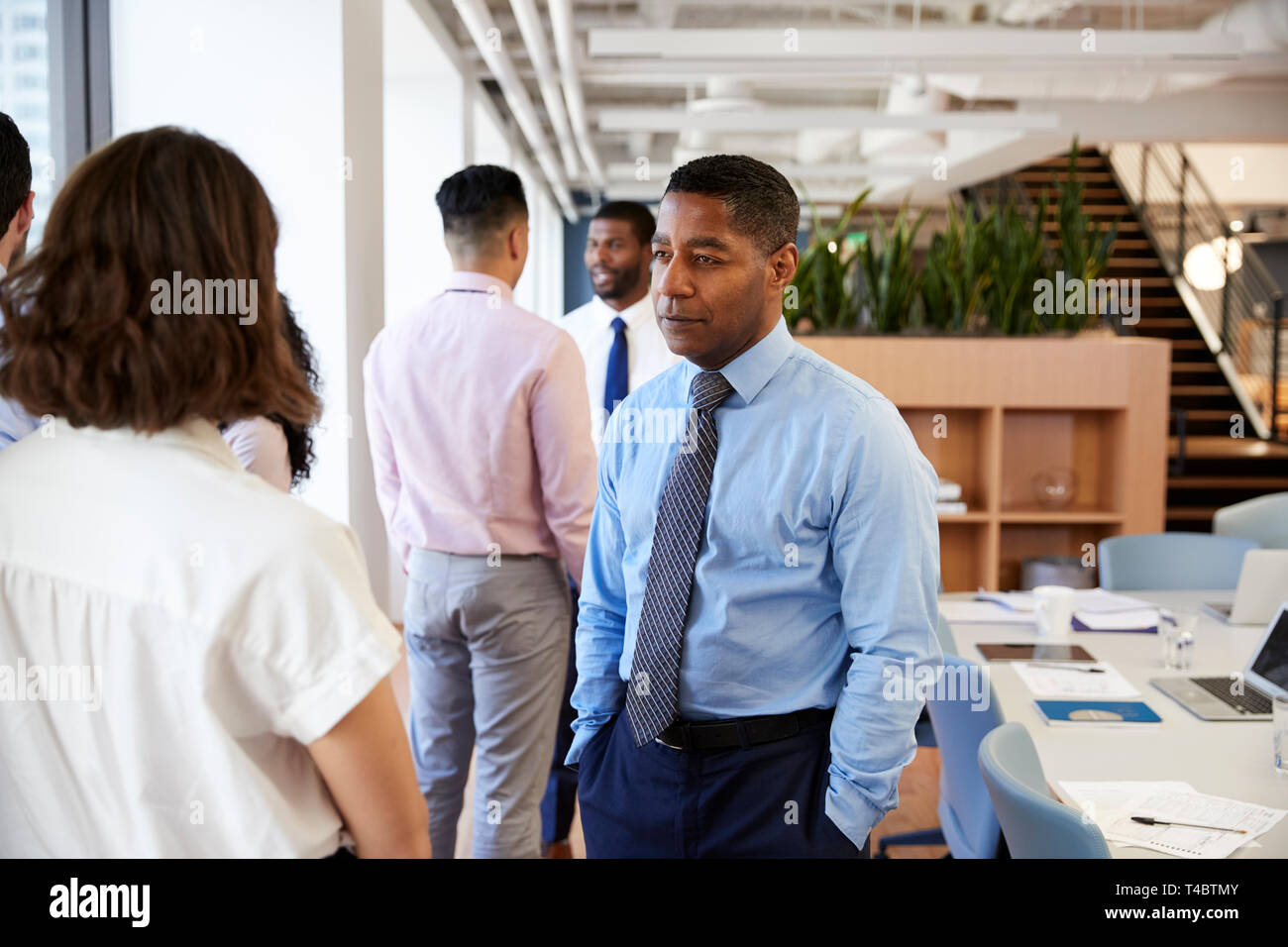 Group Of Business Colleagues Chatting In Office After Meeting Stock Photo