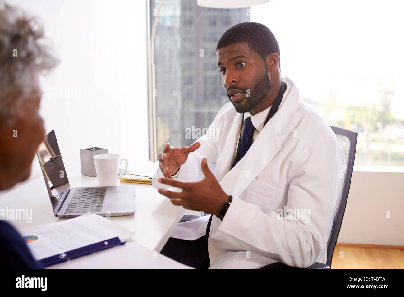 Senior Woman Meeting With Male Doctor Cosmetic Surgeon In Office Stock Photo