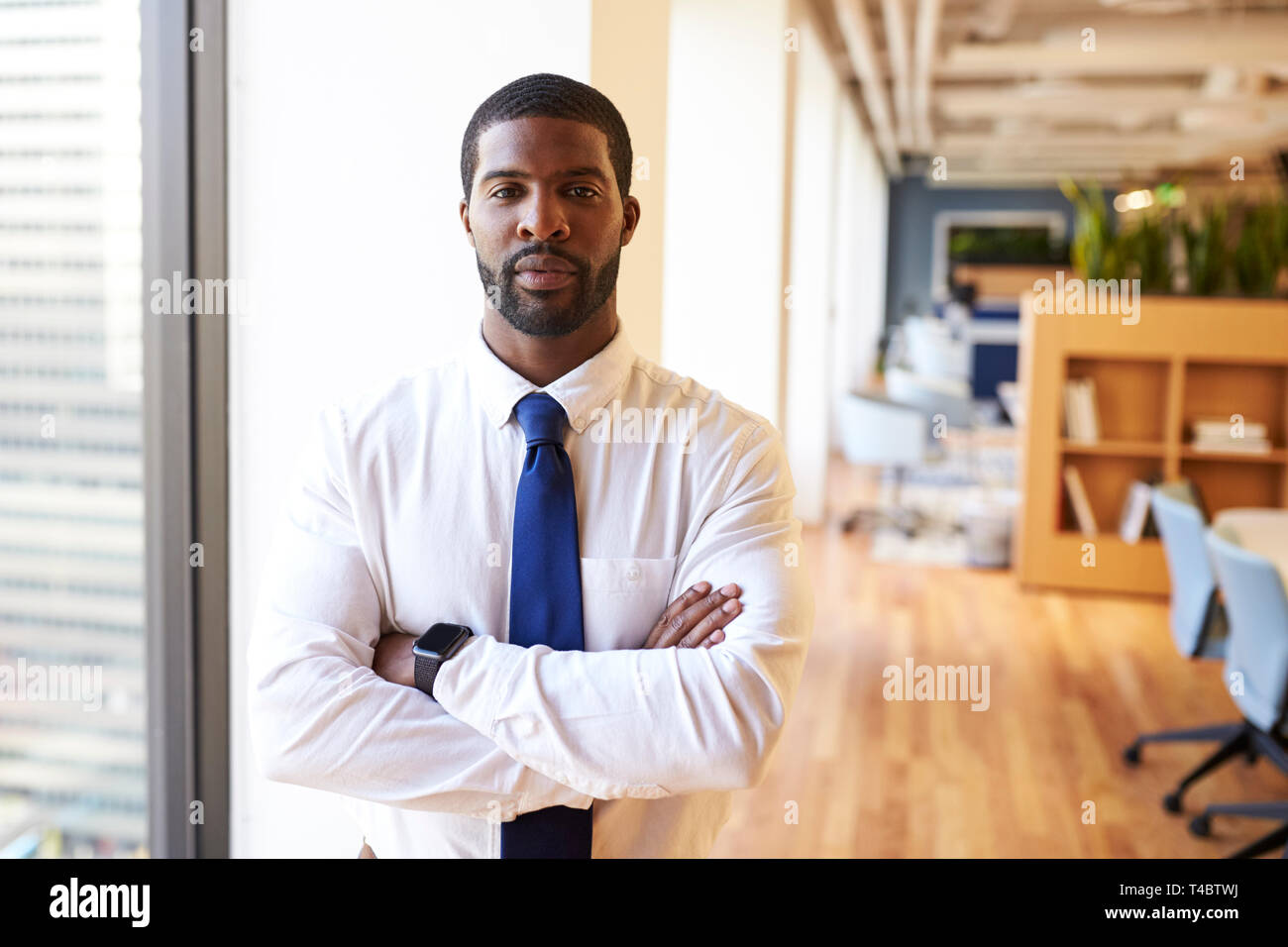 Portrait Of Businessman Wearing Smart Watch In Modern Office Standing By Window Stock Photo