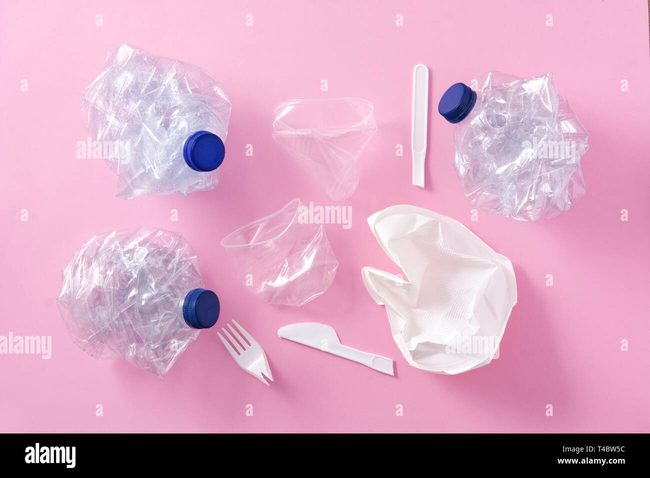 Disposable waste plastics on pink background. Top view. Stock Photo