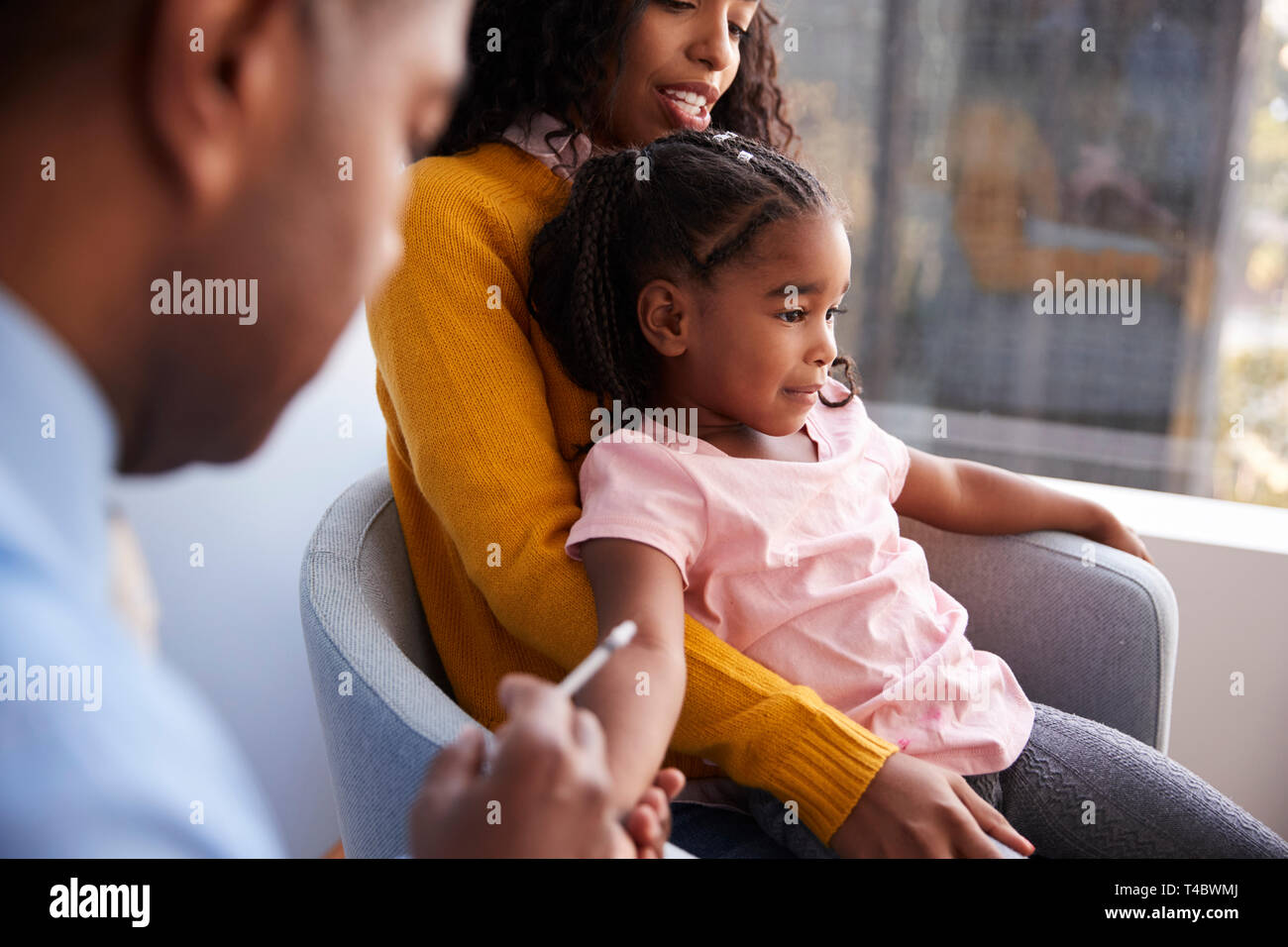Mother Taking Young Daughter For Vaccination In Doctors Office Stock Photo