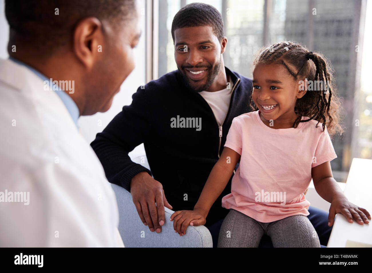 Father And Daughter Having Consultation With Female Pediatrician In Hospital Office Stock Photo