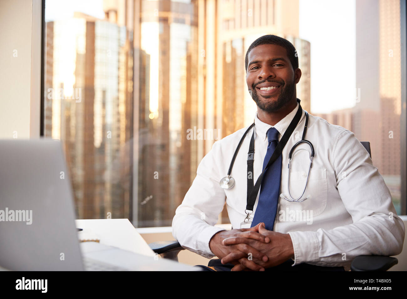 Portrait Of Smiling Male Doctor With Stethoscope In Hospital Office Stock Photo