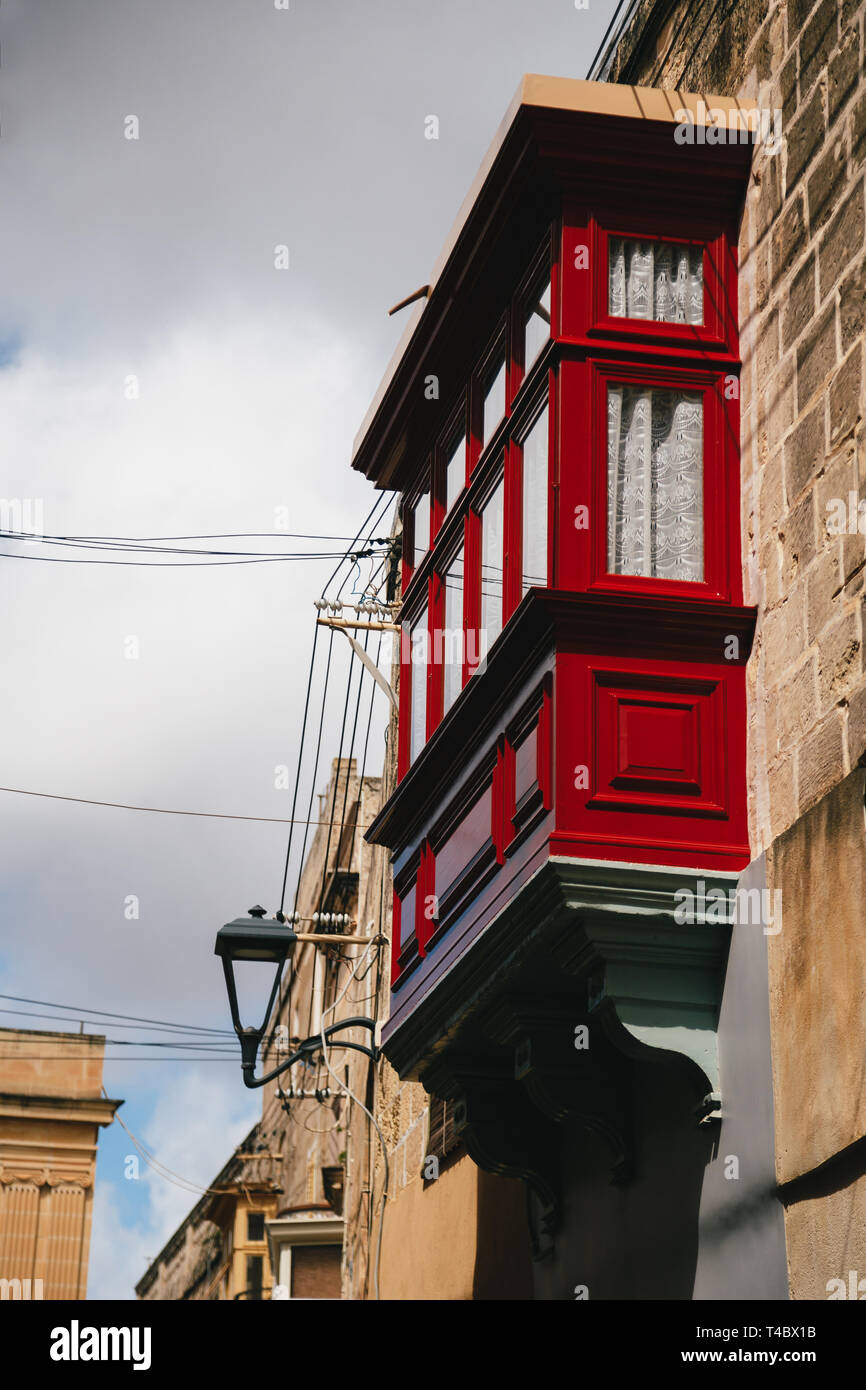 Typical traditional wooden red maltese balcony at narrow medieval street in Mdina, ancient capital of Malta, fortified medieval town. Popular Stock Photo