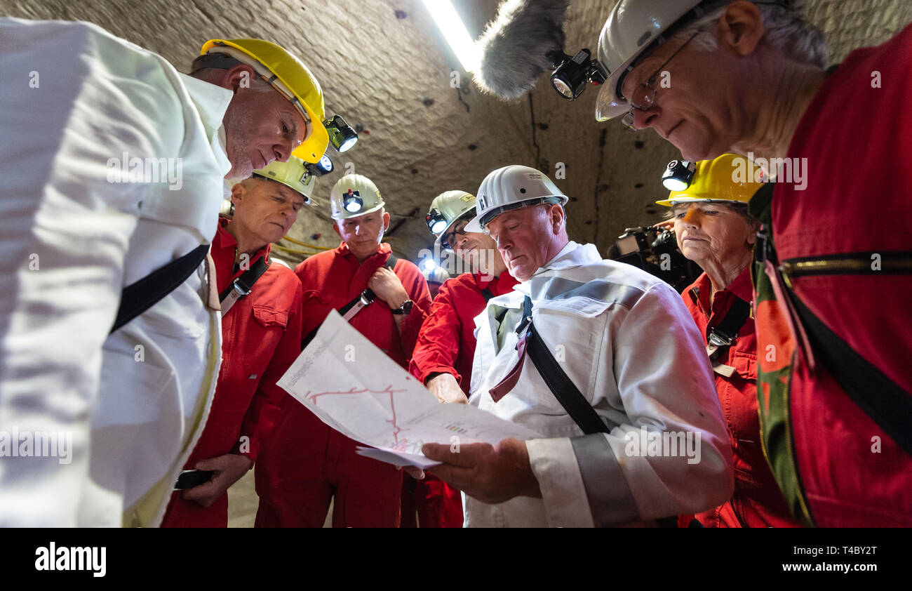 Gorleben, Germany. 15th Apr, 2019. Jochen Flasbarth (l), State Secretary in the Federal Ministry for the Environment, Nature Conservation and Nuclear Safety, is explained a map by Frank-Holger Koch (3rd from right), plant manager of Gorleben colliery. After decades of dispute over a repository for highly radioactive nuclear waste in Gorleben, the exploration area of the mine has been almost completely dismantled. During a symbolic final inspection of the salt dome it was now shown what the so-called open-keeping operation looks like. Credit: Philipp Schulze/dpa/Alamy Live News Stock Photo