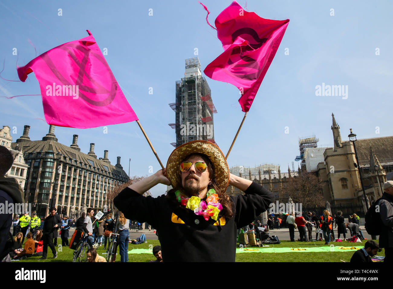 An environmental activists is seen waving flags during the demonstration. Activist protest at the Parliament Square demanding for urgent Government action on climate change, the protest was organised by Extinction Rebellion. Stock Photo