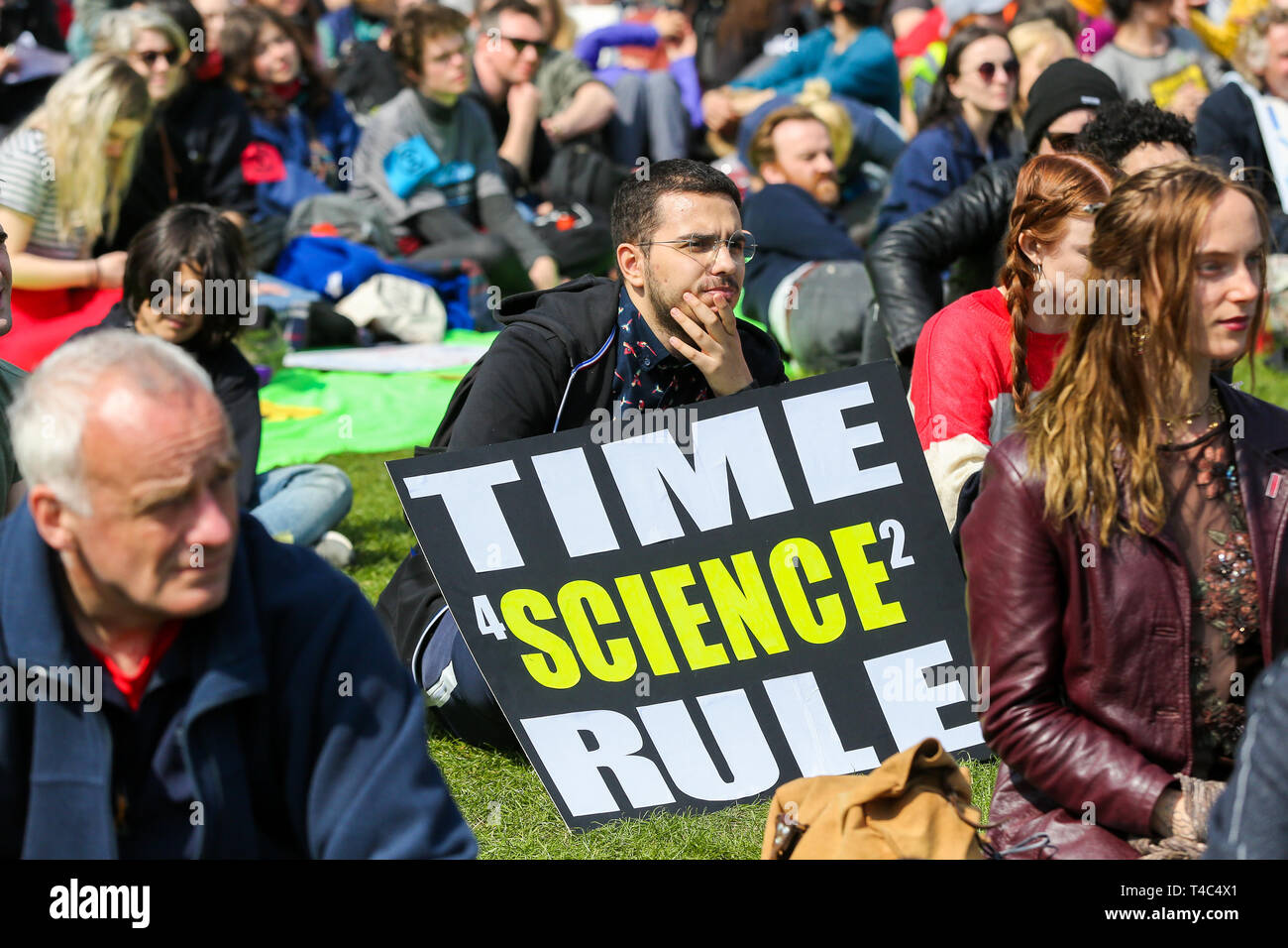 An environmental activist seen seated next to a placard that says time for science to rule during the demonstration. Activist protest at the Parliament Square demanding for urgent Government action on climate change, the protest was organised by Extinction Rebellion. Stock Photo