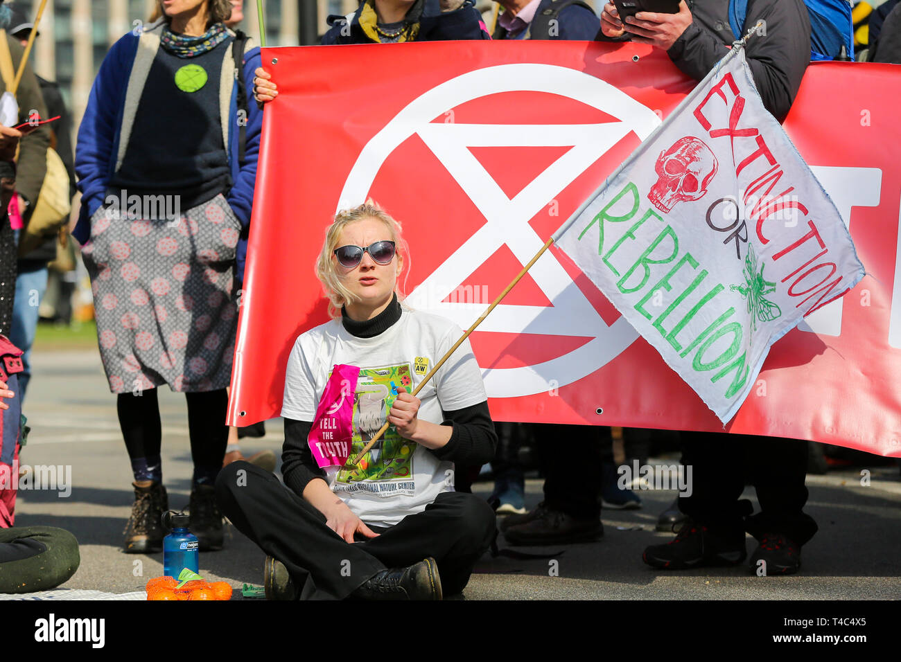An environmental activist is seen holding a banner as she takes part during the demonstration at the Parliament Square. Activist protest at the Parliament Square demanding for urgent Government action on climate change, the protest was organised by Extinction Rebellion. Stock Photo