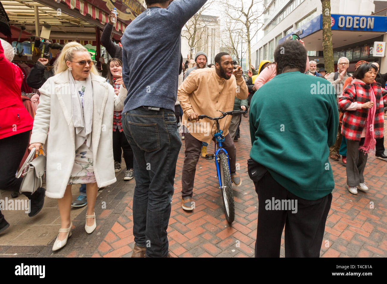 Birmingham, UK. 16th April, 2019. A diverse team of one hundred community actors, musicians and stewards alongside Saltine Theatre Company re-tell the Easter story in a live procession through Birmingham city centre. Christ is riding into the city on a bicycle. The procession finishes up at St. Philip’s Cathedral.  Peter Lopeman/Alamy Live News Stock Photo