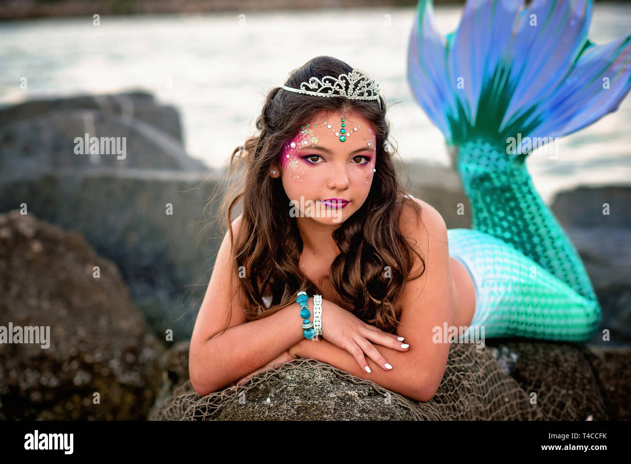 Tween mermaid on rocks Stock Photo Alamy