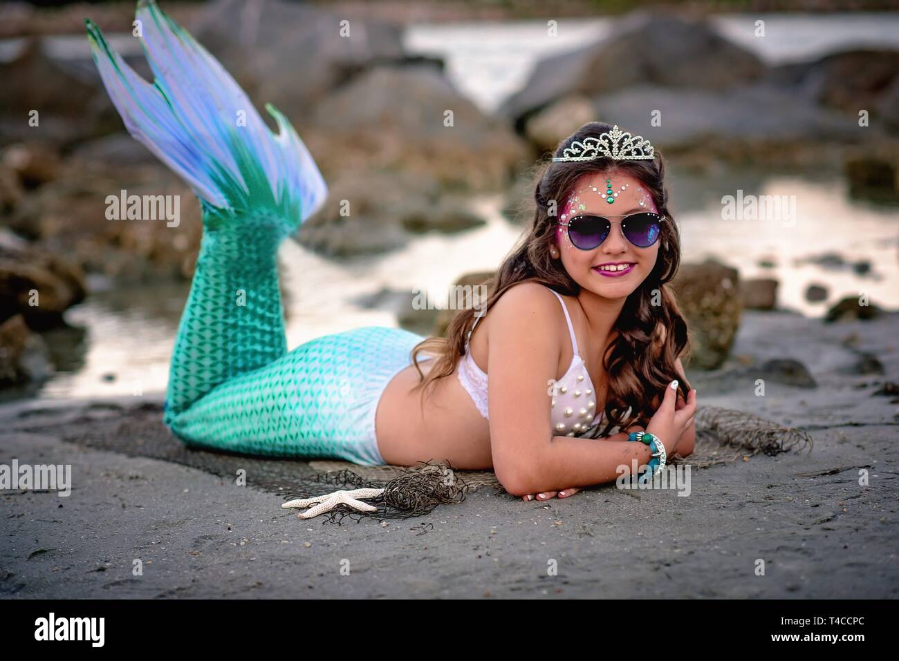 Tween mermaid on rocks Stock Photo
