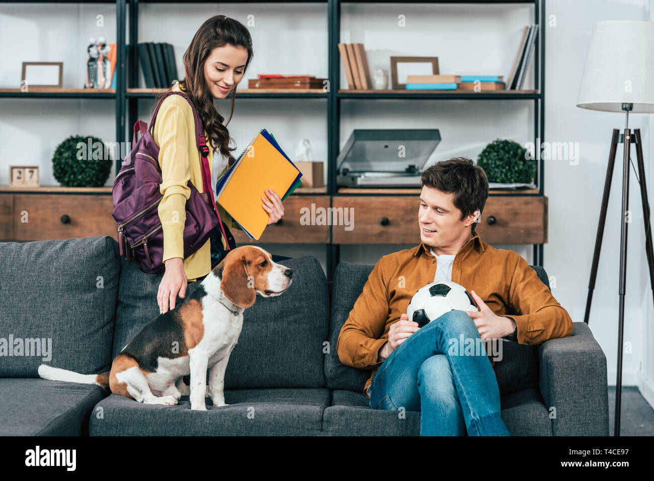 Student With Backpack And Notebooks Stroking Beagle Dog On Student With Backpack And Notebooks Stroking Beagle Dog On