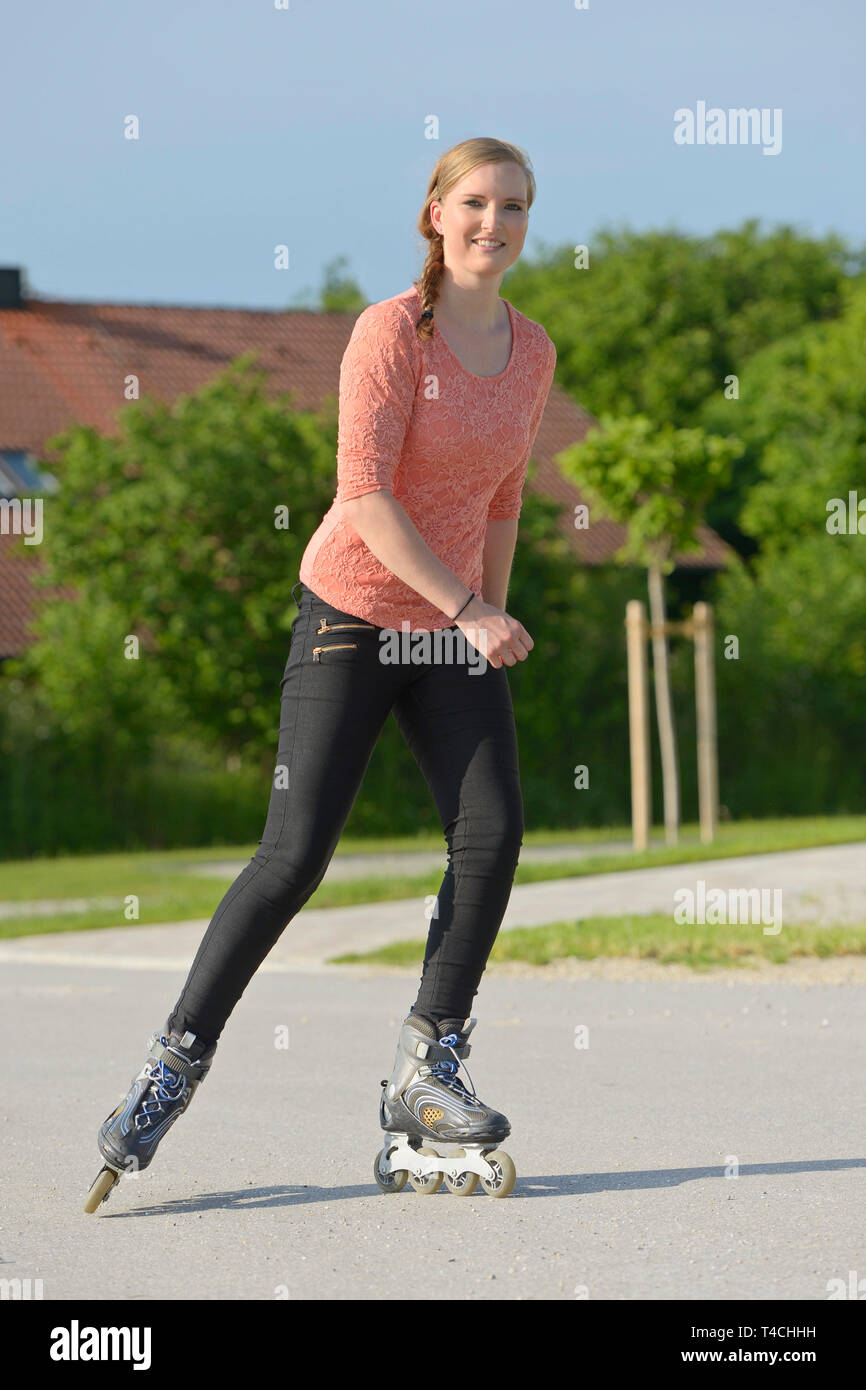 Young woman rollerblading on a small road Stock Photo