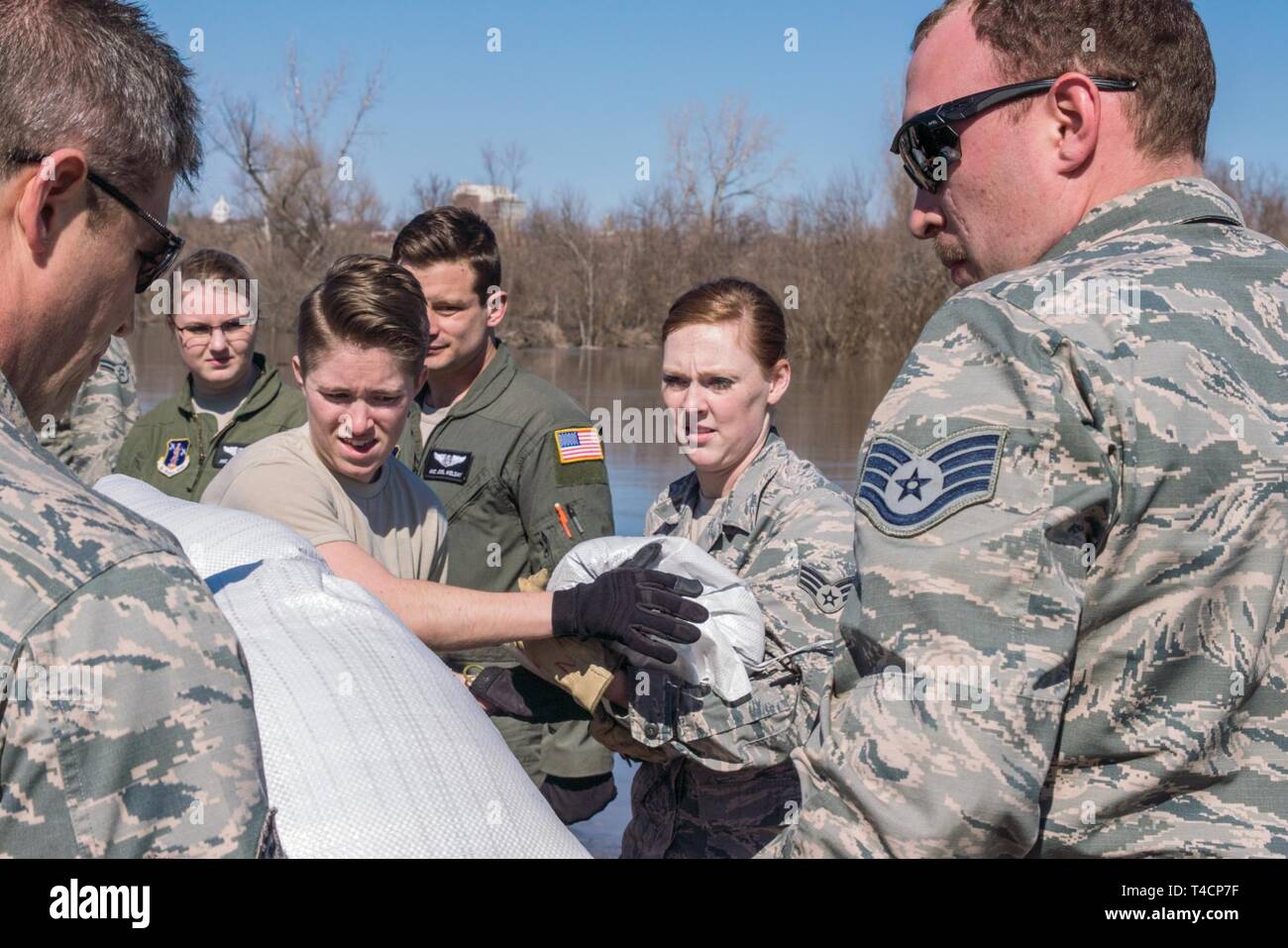 U.S. Airmen Staff Sgt. Paige Howard, left, and Senior Airman Kacie Bigham both assigned to the 139th Force Support Squadron, Missouri Air National Guard, help lay sandbags along the levee that protects Rosecrans Memorial Airport and surrounding communities on March 22, 2019. An increase in water levels of surrounding rivers and waterways caused by record-setting snowfall over the winter in addition to a large drop in air pressure caused widespread flooding across the midwest. Stock Photo