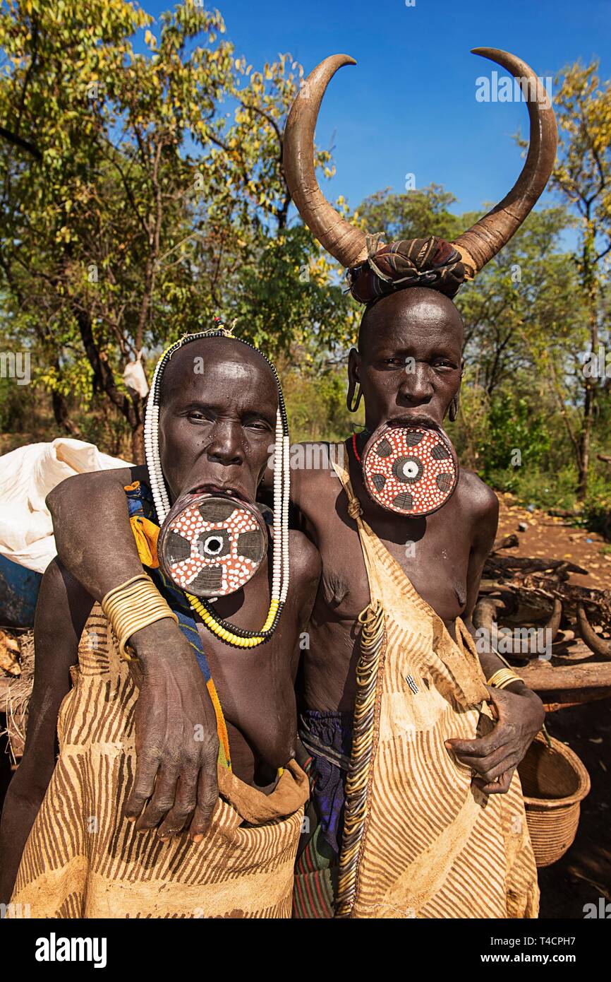 Two women with large lip plates and horns as headdress, tribe of the Mursi, Mago National Park, Southern Nations Nationalities and Peoples' Region Stock Photo