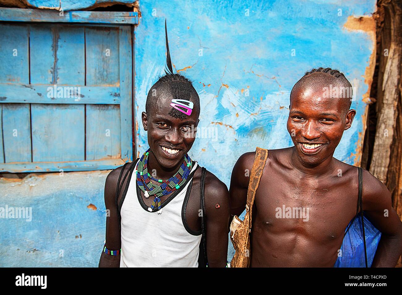 Laughing young men of the Hamer ethnic group with colorful hair clips and pearl jewelry, Dimeka, Lower Omo Valley, Omo region, South Ethiopia Stock Photo