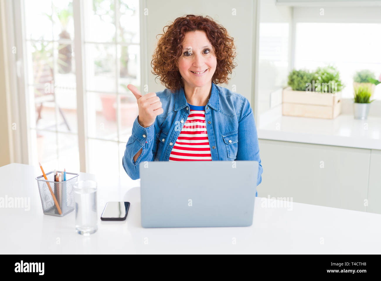 Senior woman working using computer laptop pointing and showing with ...