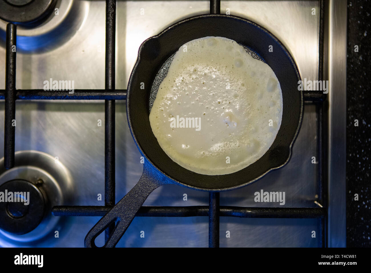 Image from above of frying pan with pancake on gas stove Stock Photo
