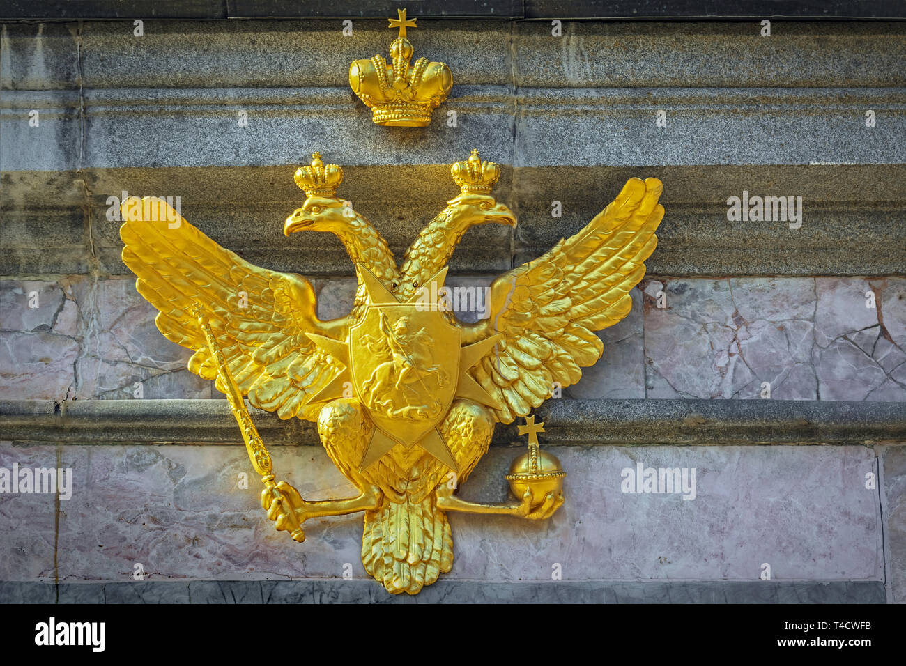 The gilded figure of a double-headed eagle with the crown of the Russian Empire, fortified on a pedestal of marble. Stock Photo