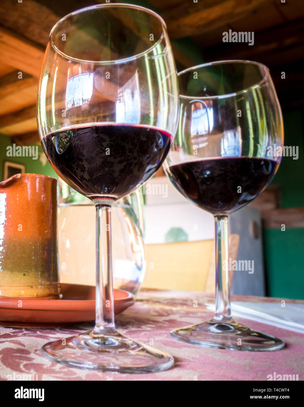 Glass of red wine on a table in rustic restaurant Stock Photo