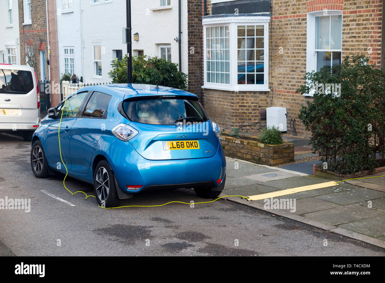 Renault Zoe electric car vehicle with batteries being charged up using an electrical cable from a domestic house. UK. (106) Stock Photo