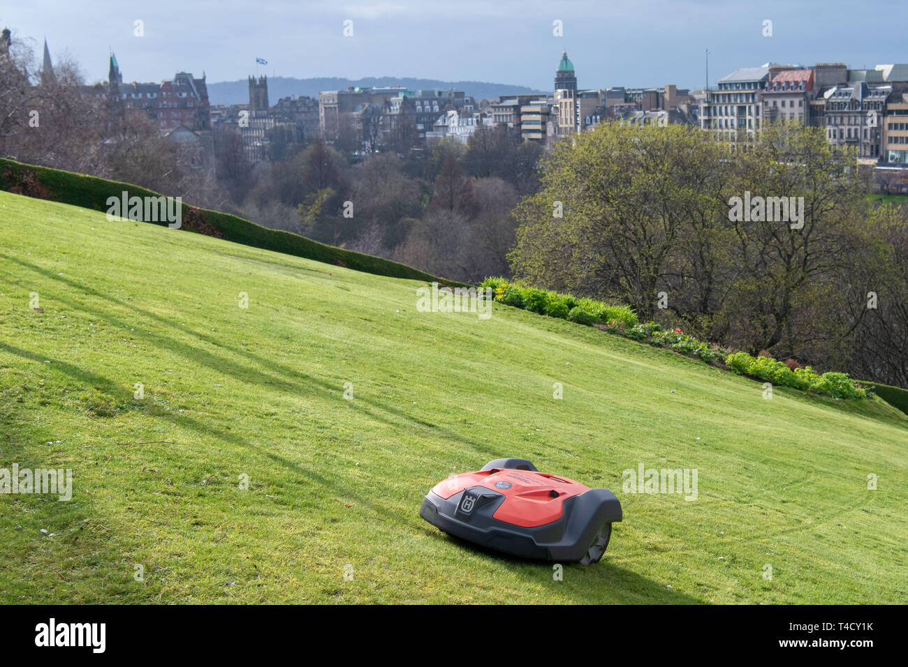 A Robotic automated lawnmower cuts the grass on the mound Stock Photo