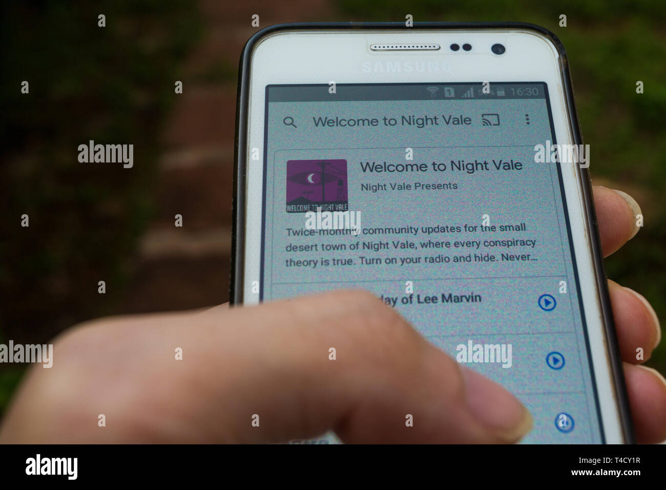 A smartphone with ‘Welcome to Night Vale’ podcast playing, outdoors Stock Photo