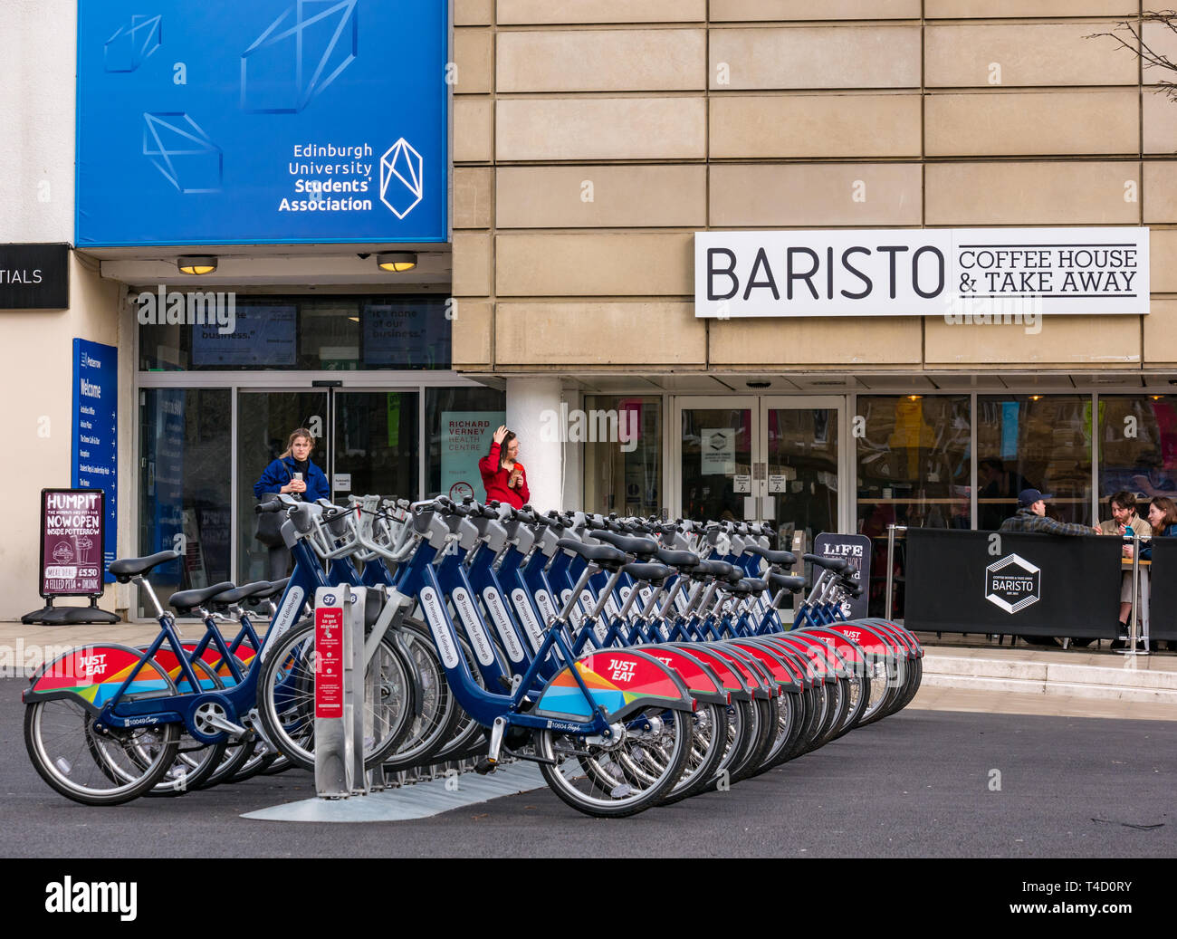 Just Eat rental bicycles outside Edinburgh University Students Association, Bristo Square, Edinburgh, Scotland, UK Stock Photo
