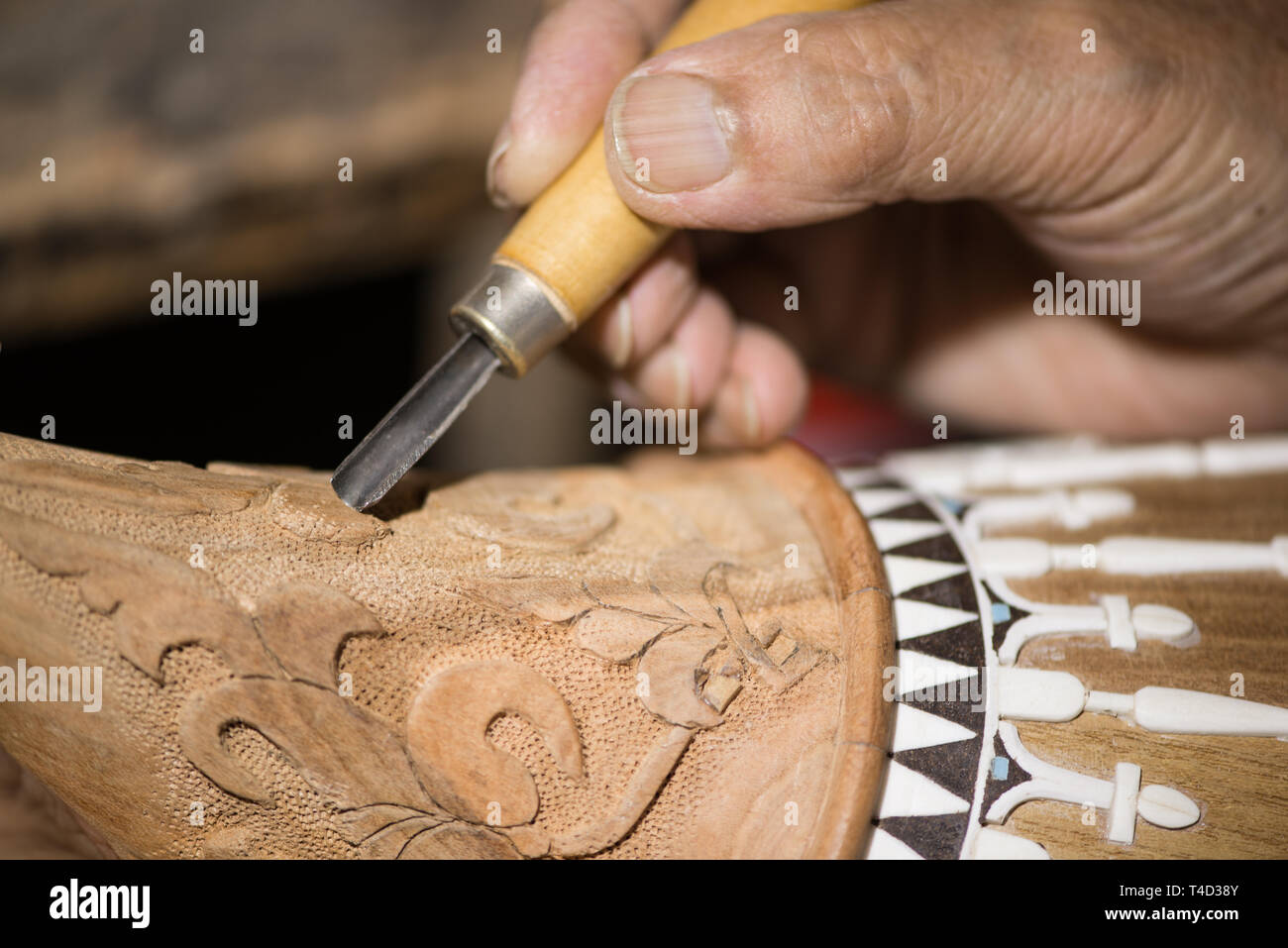 adult master restores old musical instruments. wood carving Stock Photo