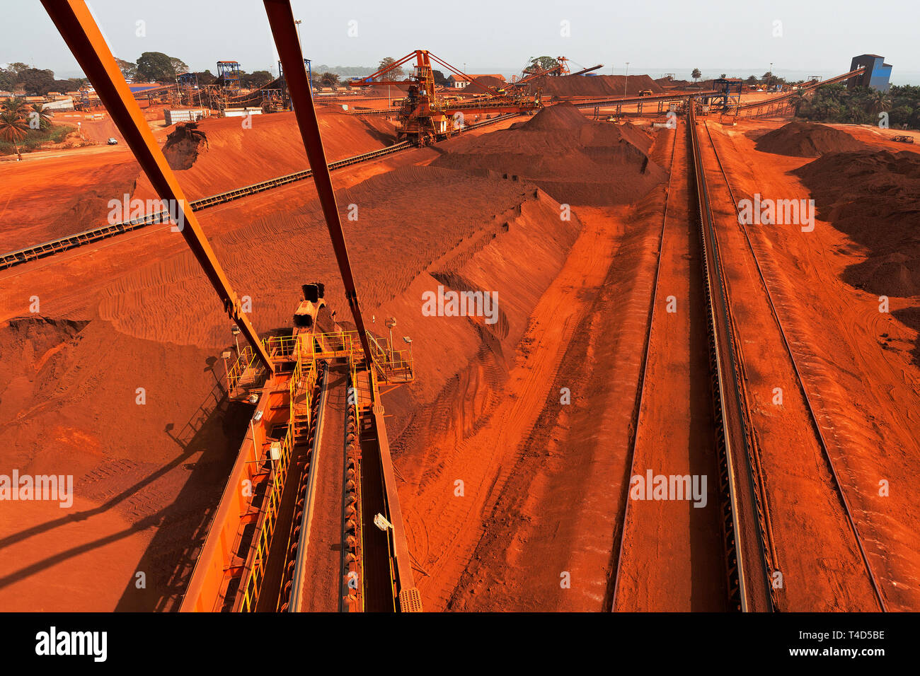Port operations for managing and transporting iron ore. From reclaimer stacker over stockyard & new then working Butterfly stacker to Junction House Stock Photo