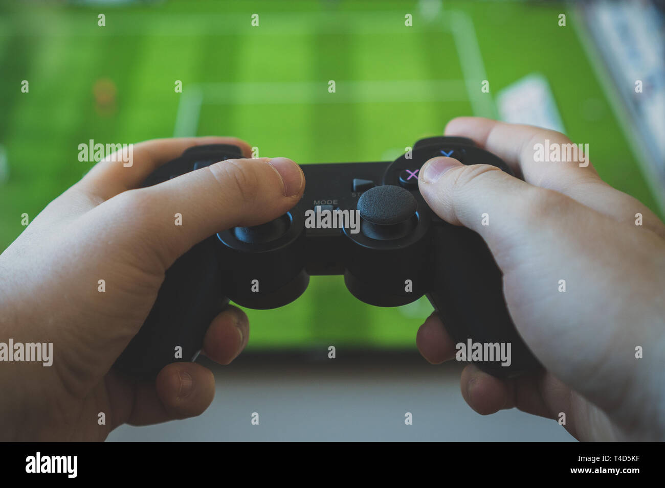 Man playing soccer video game on TV. Gamepad controller in hands Stock  Photo - Alamy