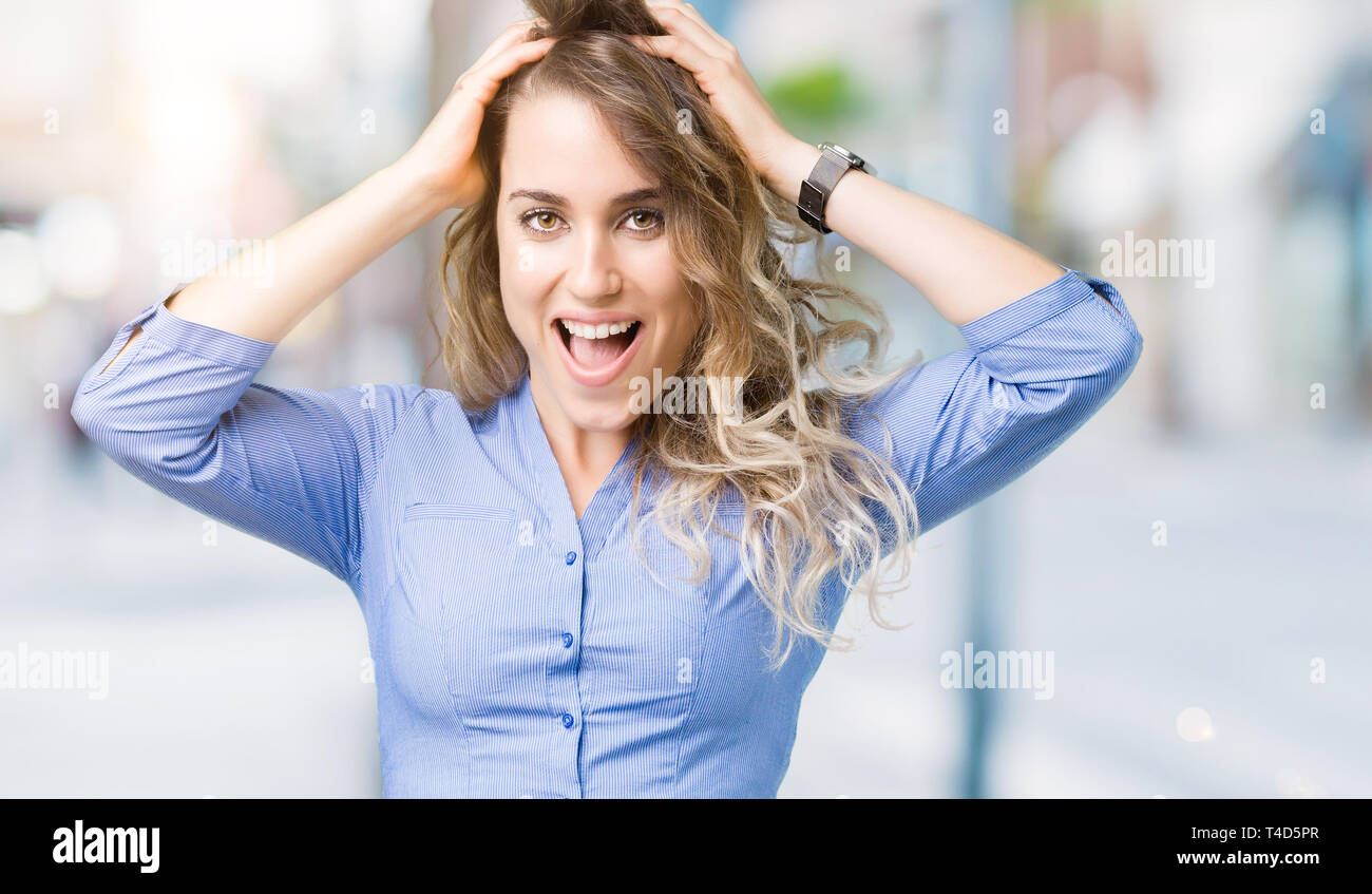 Beautiful young blonde business woman over isolated background Crazy ...