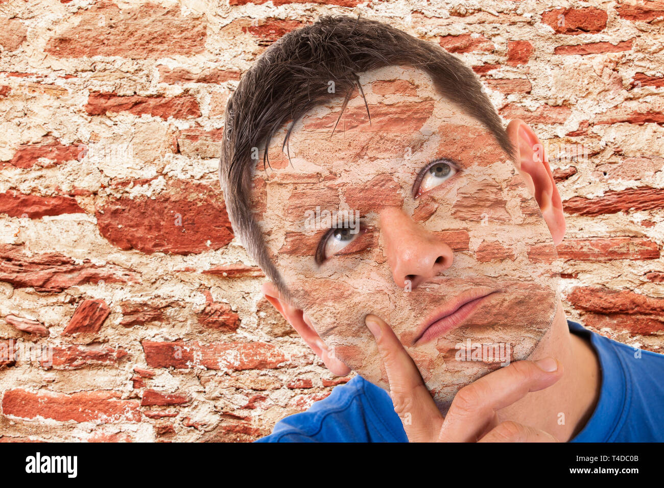 Camouflage -man camouflaged in front of a wall Stock Photo