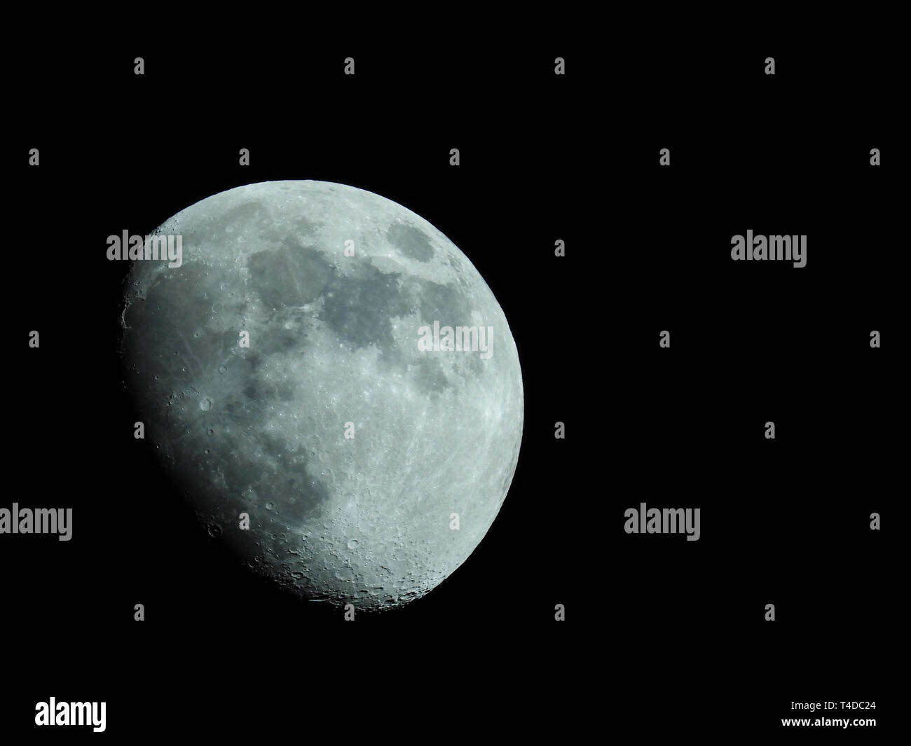 a close-up of a three-quarter moon in the night sky Stock Photo