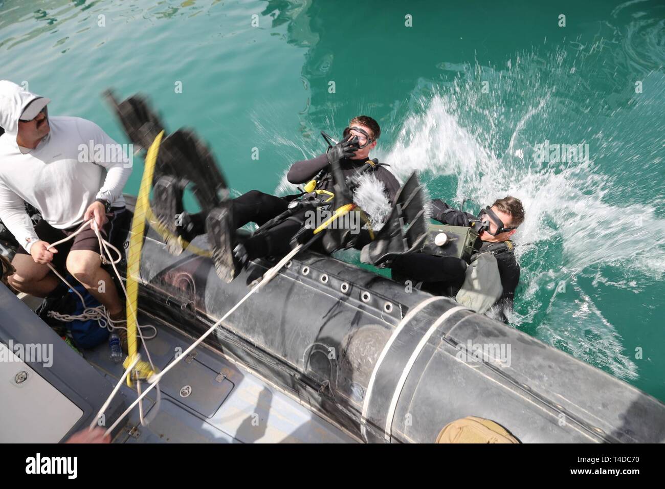 KUWAIT (March. 18, 2019) U.S. Navy Explosive Ordnance Disposal Technician 1st class Devin Giles, left, and 2nd class Michael Peterson enter the water during Limpet mine response procedures during exercise Eager Response 19. Eager Response 19 is a bilateral explosive ordnance and mine countermeasures exercise between the U.S. Navy and the Kuwait Navel Forces, allowing both nations to share knowledge and experiences to enhance mutual maritime capabilities and interoperability. Stock Photo