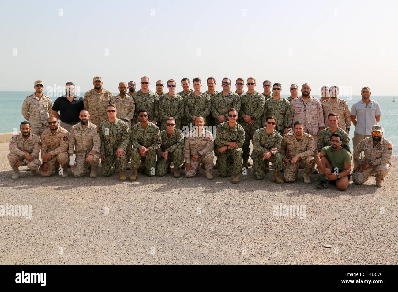 KUWAIT (March. 18, 2019) U.S. Navy personnel and members of the Kuwait Naval Forces take a group photo during exercise Eager Response 19. Eager Response 19 is a bilateral explosive ordnance and mine countermeasures exercise between the U.S. Navy and the Kuwait Navel Forces, allowing both nations to share knowledge and experiences to enhance mutual maritime capabilities and interoperability. Stock Photo