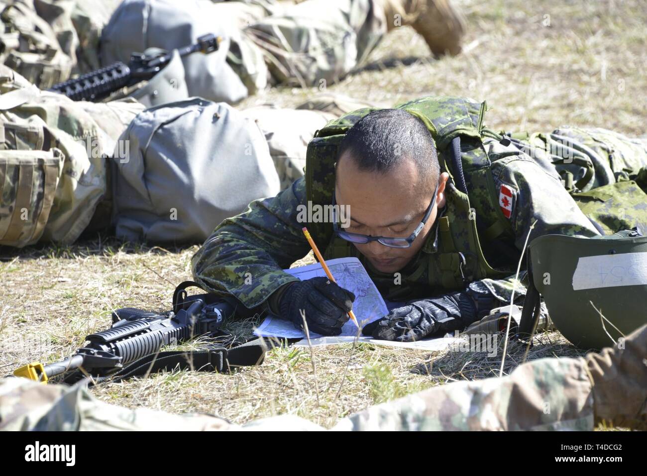 A Canadian soldier plots map coordinates during the land navigation portion of testing for the Expert Field Medical Badge at the 7th Army Training Command’s Grafenwoehr Training Area, Germany, March 22, 2019. To qualify for the badge, Soldiers from U.S. Army Europe, NATO, and other allied partners must complete events such as land navigation, weapons function checks, written tests, medical treatments and evacuations, and a 12 mile ruck march. (U. S. Army Stock Photo
