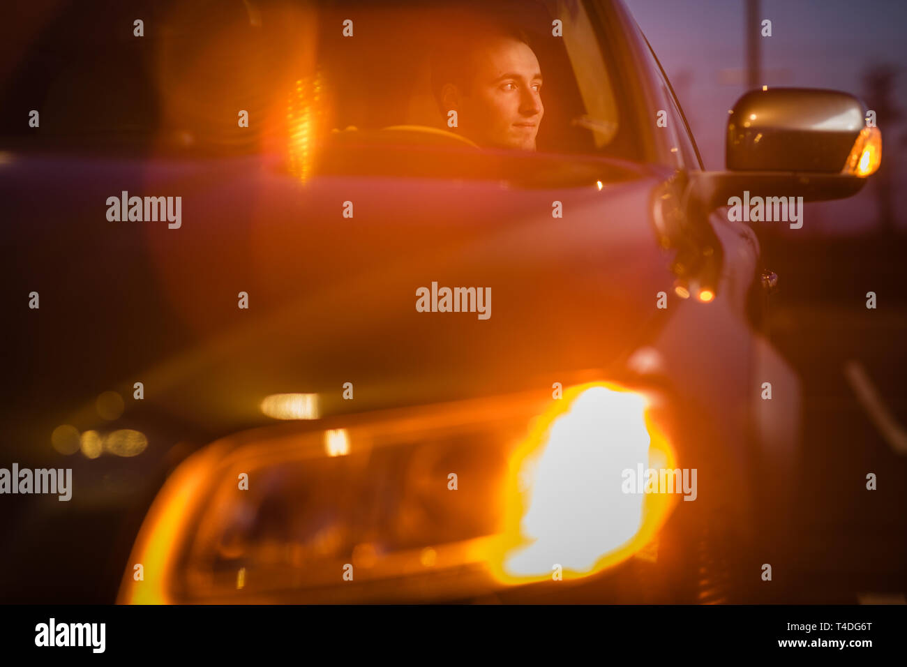 Handsome young man driving his car at night (color toned image Stock ...
