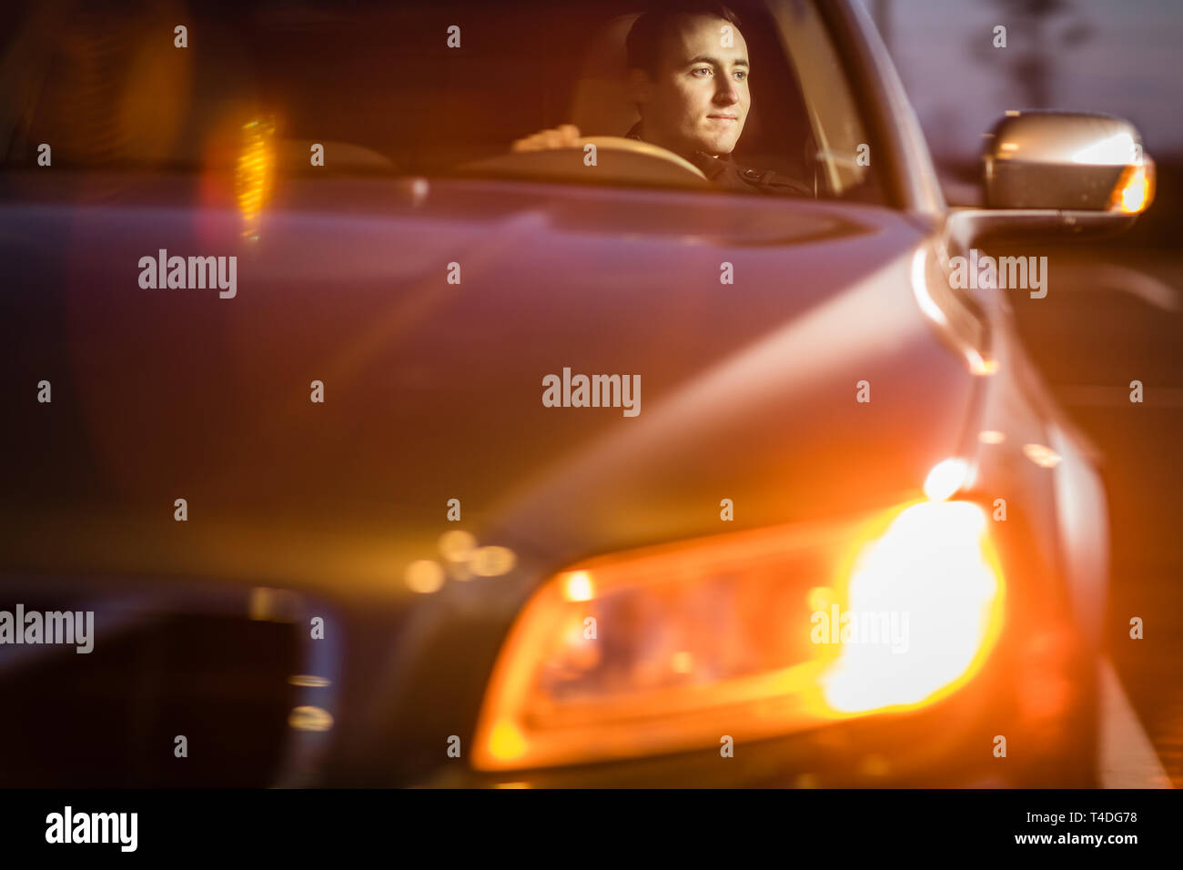 Handsome young man driving his car at night (color toned image Stock ...