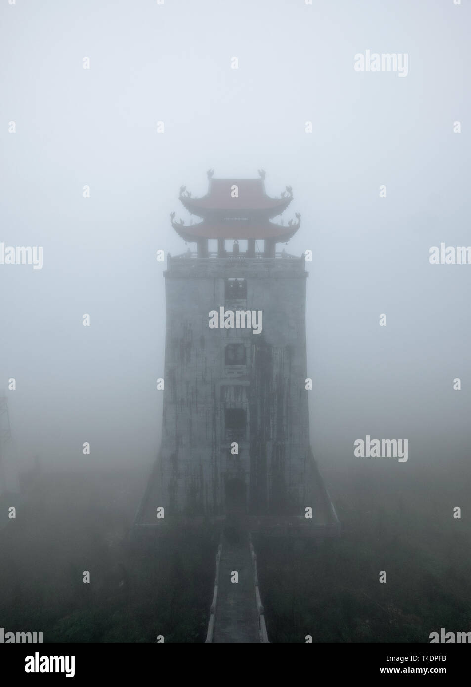 Temple tower on peak mountain in misty at Fansipan, Sapa, Vietnam Stock Photo