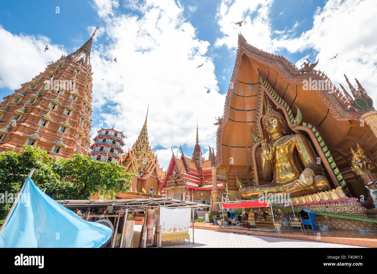Architecture golden church with big buddha and pagoda in Wat Tham Sua, Kanchanaburi, Thailand Stock Photo