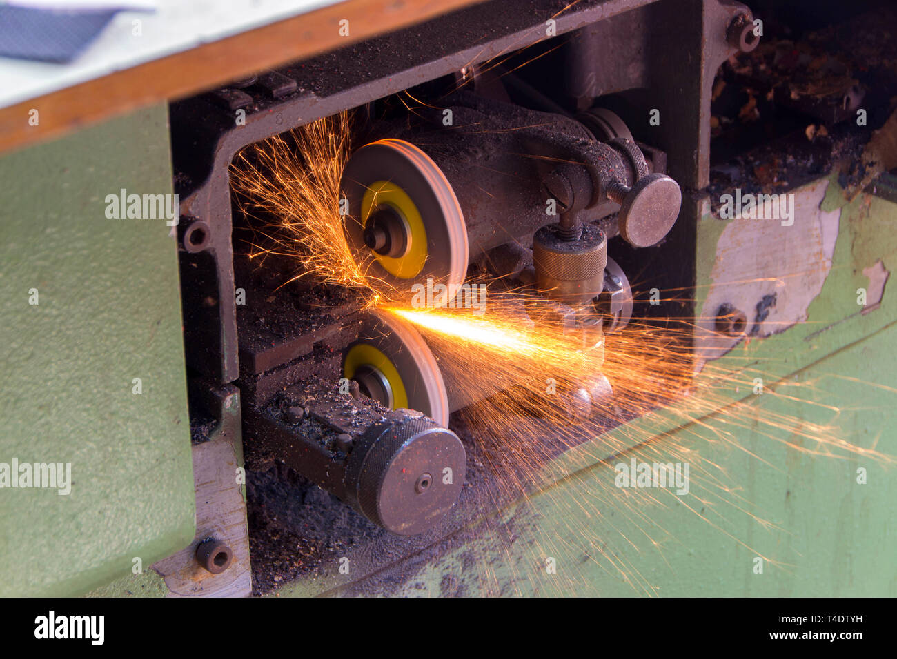 Mechanical stone for sharpening knives of split machines for leather. Sparks from grinding stone Stock Photo
