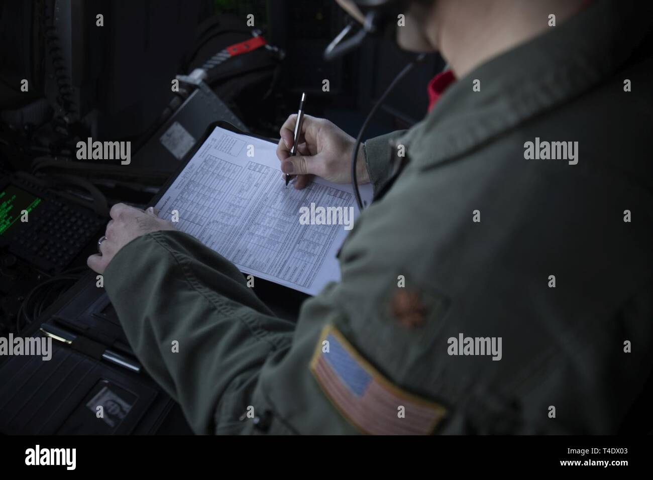 Maj. Brian Dendy, 36th Airlift Squadron assistant director operations, writes a score on a judging sheet during the Yokota C-130J Rodeo over the Kanto Plain, March 22, 2019. The 36th Airlift Squadron held a tactical airlift Rodeo competition to test and improve combat tactics in a competitive environment with a split focus on pilot and loadmaster skills. Stock Photo