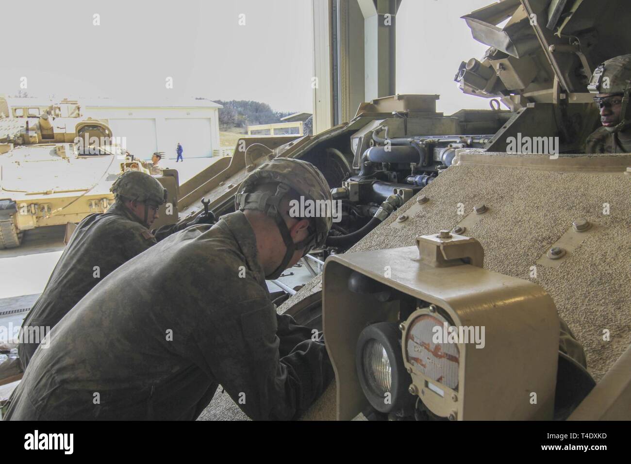 U.S. Army Soldiers assigned to 1st Battalion, 16th Infantry Regiment, 1st Armored Brigade Combat Team, 1st Infantry Division perfom vehicle services on an M2 Bradley Fighting Vehicle in the maintenance bay at Novo Selo Training Area, Bulgaria, March 26, 2019. The unit is deployed to Bulgaria in support of the Atlantic Resolve Mission. Stock Photo
