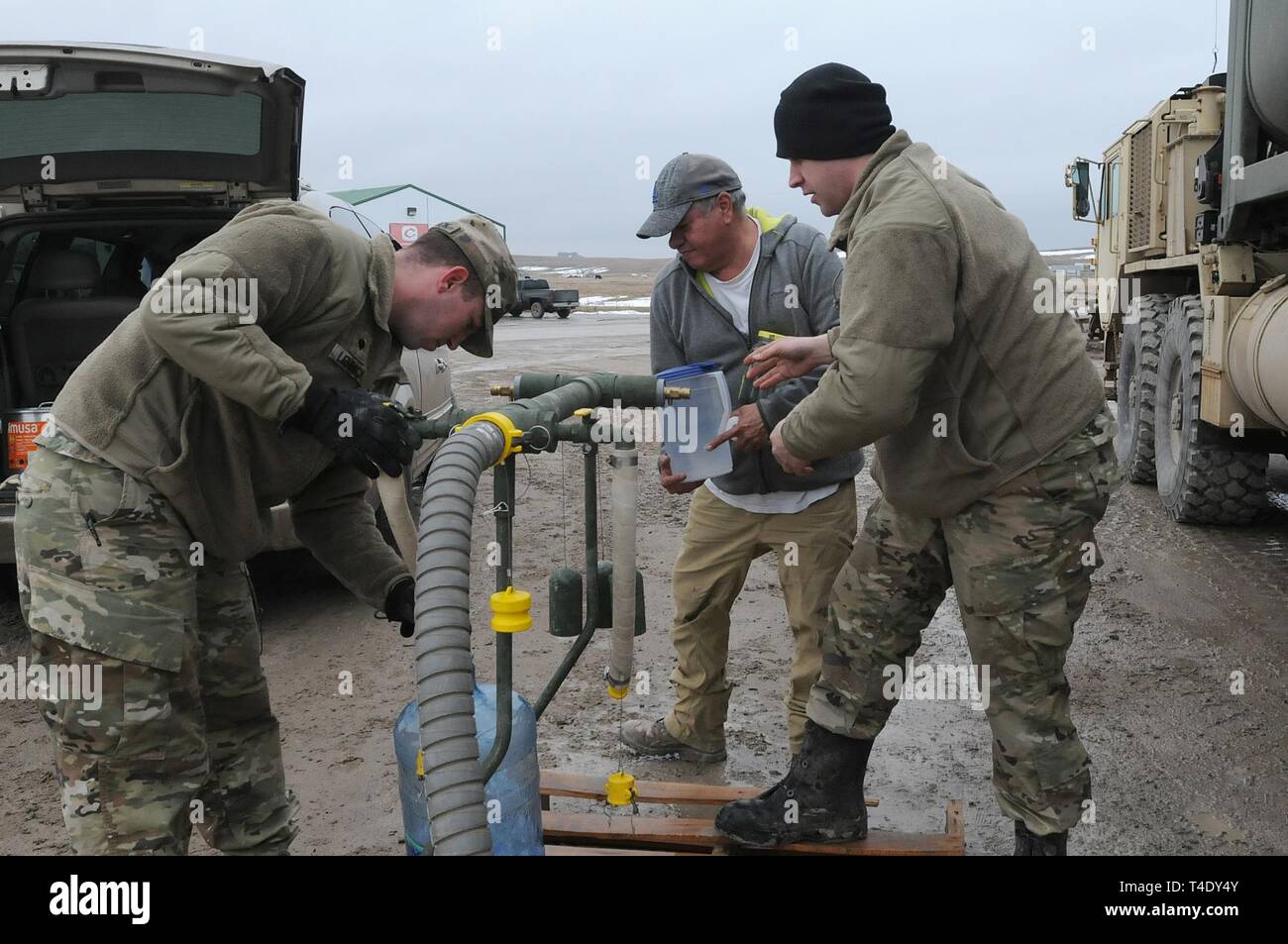 U.S. Army Sgt. David Fuegen, right, and Spc. Tracy Lennick, members with Company A, 139th Brigade Support Battalion, South Dakota Army National Guard, provide drinkable water to Lester Iron Cloud at Sharps Corner, S.D, on the Pine Ridge Reservation, March 25, 2019. Thirteen SDARNG Soldiers were activated for state duty in Pine Ridge after a county waterline failed due to extreme flooding leaving residents in seven communities without water in their homes. Stock Photo