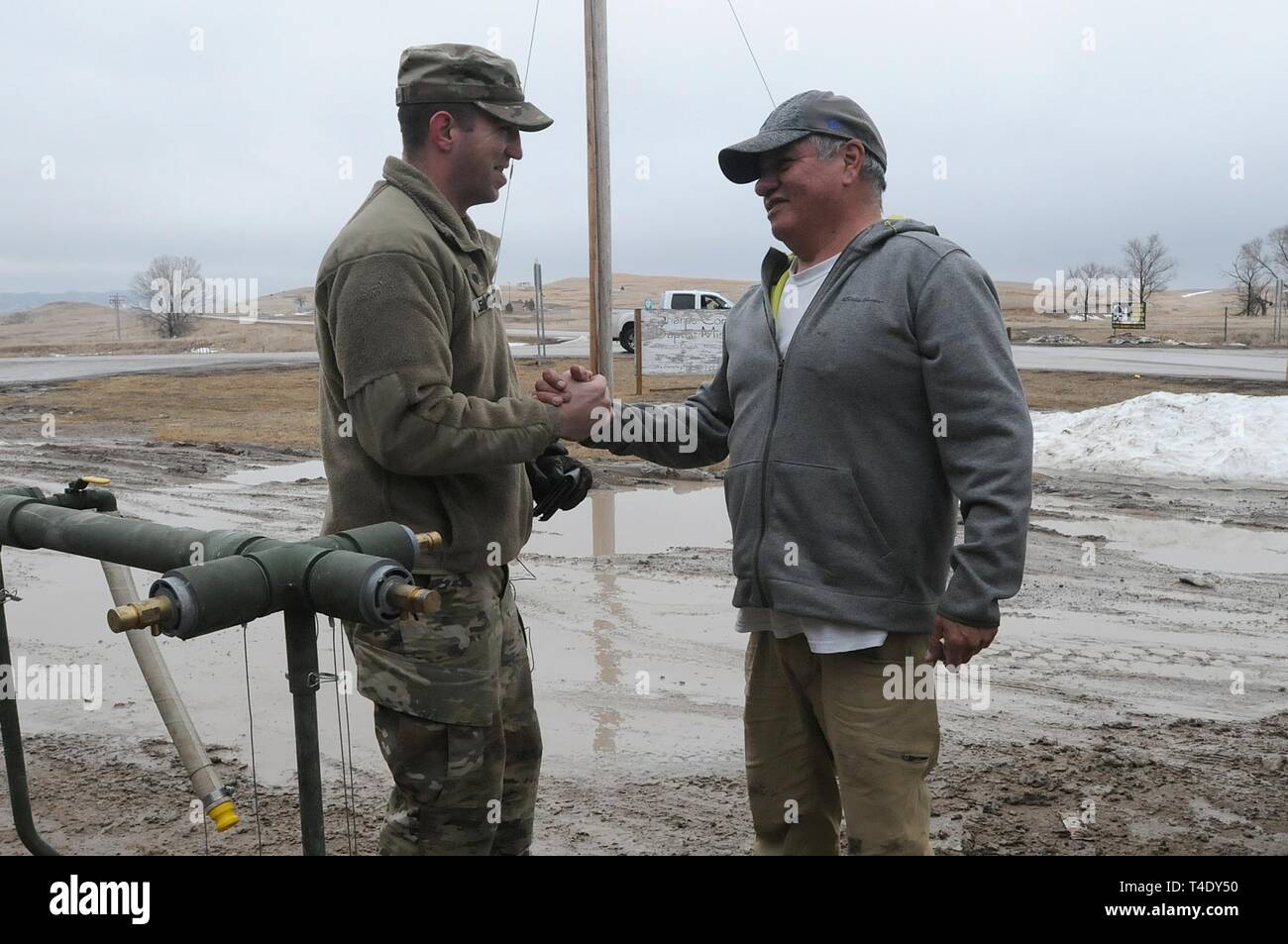 Lester Iron Cloud thanks U.S. Army Spc. Tracy Lennick, with Company A, 139th Brigade Support Battalion, South Dakota Army National Guard, after receiving drinkable water at Sharps Corner, S.D, on the Pine Ridge Reservation, March 25, 2019. Thirteen SDARNG Soldiers were activated for state duty in Pine Ridge after a county waterline failed due to extreme flooding leaving residents in seven communities without water in their homes. Stock Photo