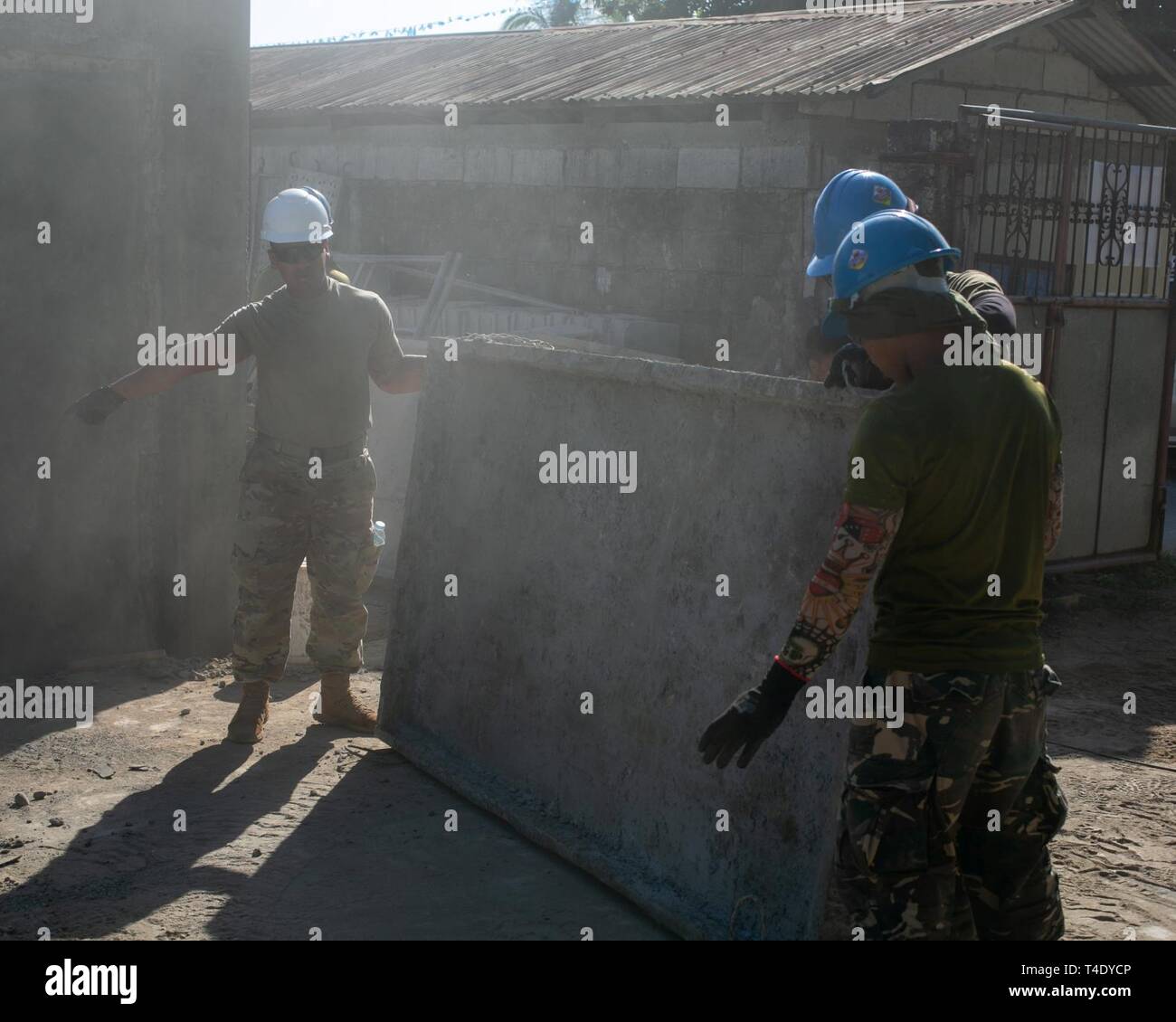 U.S. Army Spc. Sakrin Dahao, left, and Philippine Air Force Airman 2nd Class Ronel Vistal, right, move a cement tray in Pagasa, Bataan, Philippines, March 25, 2019. Two new classrooms are being constructed with the combined efforts of the U.S. Army and the Philippine Air Force as part of Exercise Balikatan 2019. Balikatan is a military training exercise hosted by the Philippines between the AFP and U.S. military, along with participants from the Australian Defence Force. Lewis, a Lafayette, La. native, is a combat engineer with 561st Engineering Support Company, 84th Engineering Battalion from Stock Photo